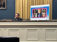Rep Aaron Bean, R-F.L. sitting with a sign behind him with false identification log in attempts with the title "The Swindler Barbie"