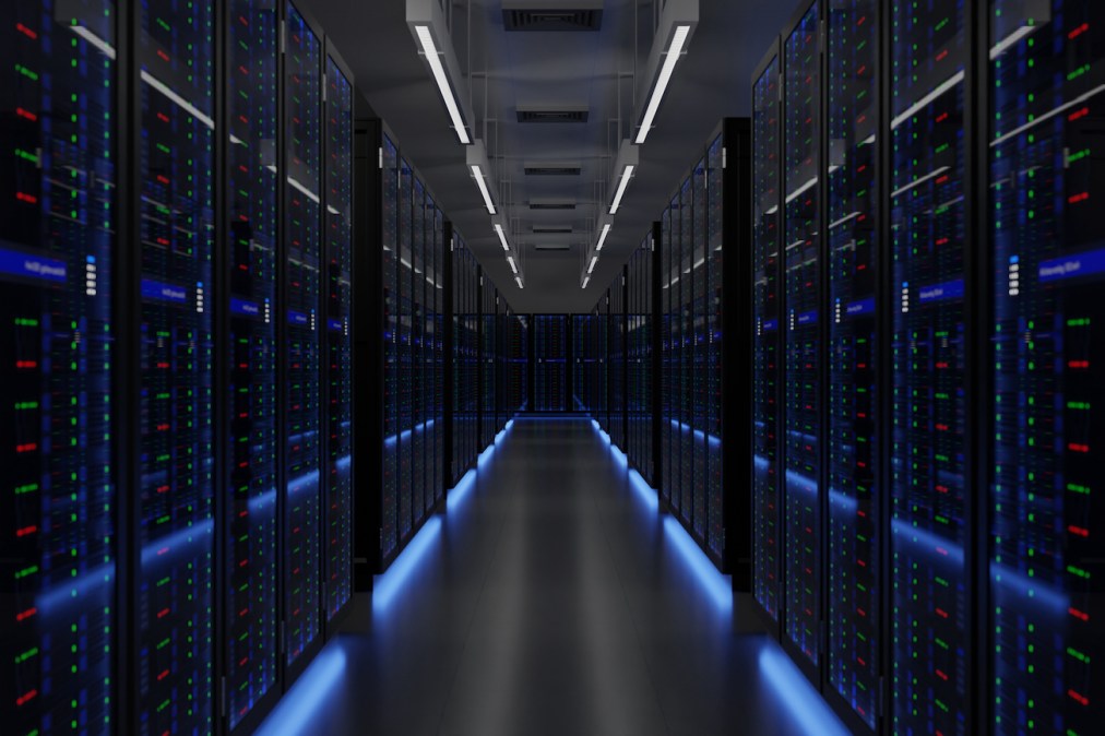 A server room with blue reflected light and some lights over the hall.