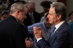 U.S. Secretary of State Antony Blinken and the department's chief data and artificial intelligence Officer, Matthew Graviss, are pictured from behind, acknowledging applause after a fireside chat on AI. The officials are looking at each other, appearing to both be mid-clap. The audience is in the background.