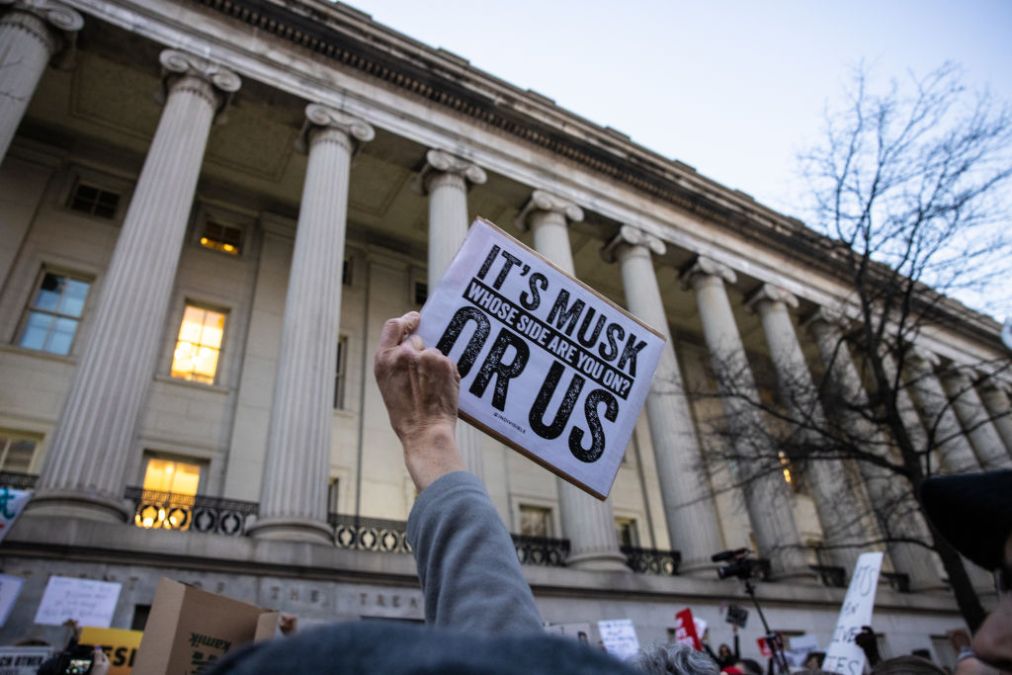 a protestor holds up a sign