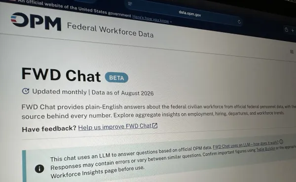 The photo shows photo of Federal Workforce Data Chat (FWD Chat) open on a computer screen. The banner across the top has the OPM logo and below that, the page reads "FWD Chat Beta."